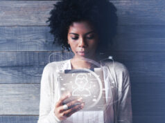Futuristische Technologie und Kommunikation. Schönes lächelndes schwarzes Mädchen mit Afro-Frisur, das einen digitalen Tablet-PC oder ein Touchpad benutzt, E-Mails checkt oder Nachrichten tippt. Weltweite Verbindung